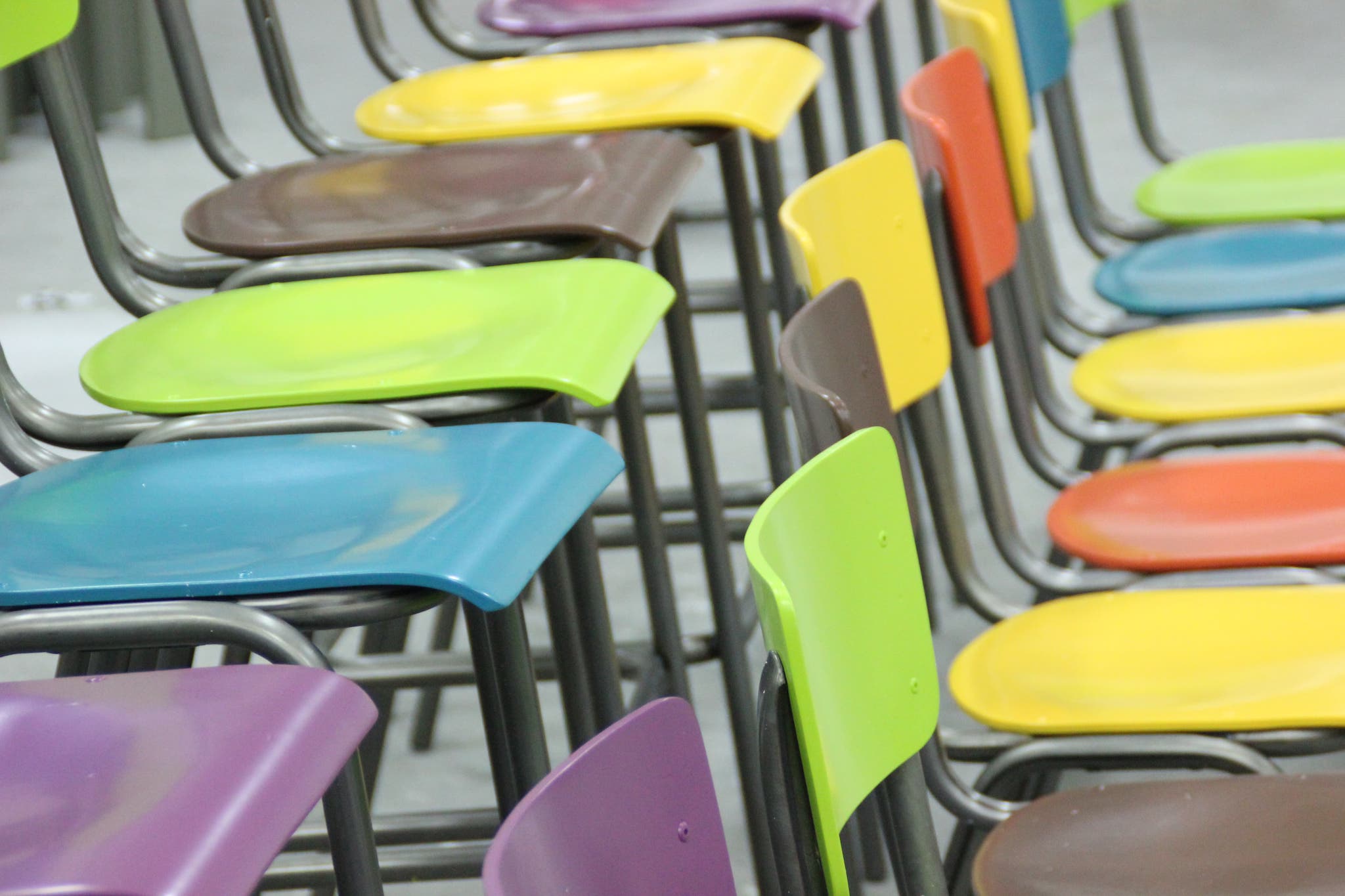 Stoelen in verschillende kleuren op een rij in een meubelspuiterij
